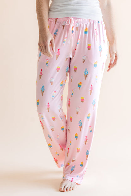 Model wearing Pink Women's Lounge Pants in Ice Cream print with drawstring under white camisole on beige background