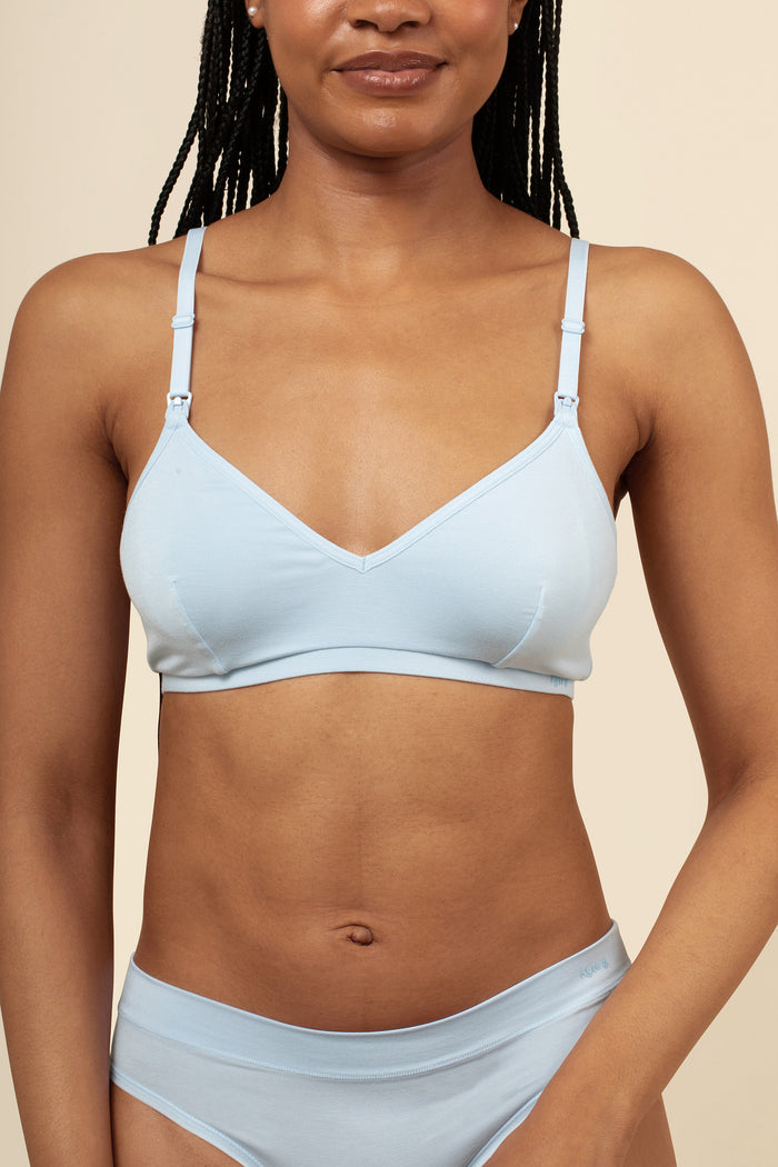 Woman wearing a light blue bra and panties set against a beige background