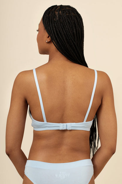 Woman wearing a light blue bikini set on a beige background