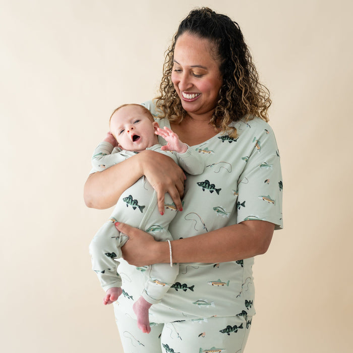 Woman wearing Kyte Baby Women's Relaxed Fit V-Neck in Fishing with Infant in matching romper