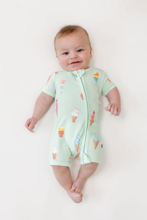 Baby wearing a Mint Ice cream print zippered shortall romper on a beige background