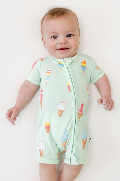 Baby smiling in zippered shortall romper with Mint Ice cream print on a beige background