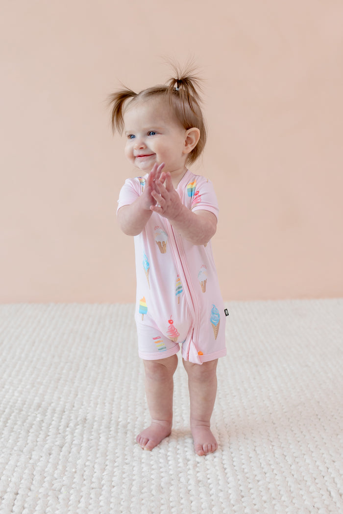 Child wearing a Sakura Ice cream print Zippered shortall romper a beige background