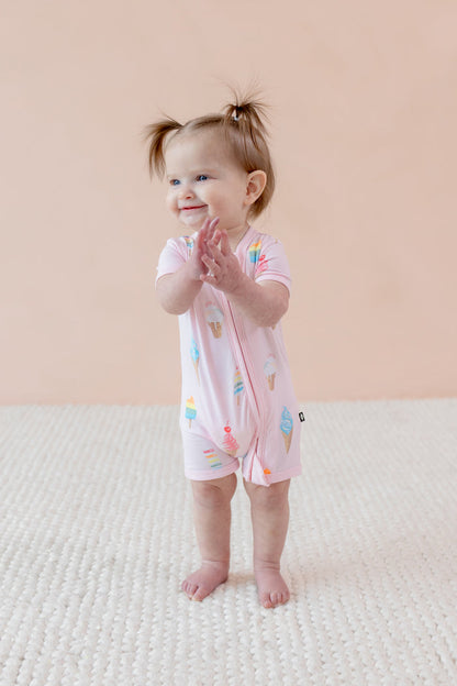 Child wearing a Sakura Ice cream print Zippered shortall romper a beige background