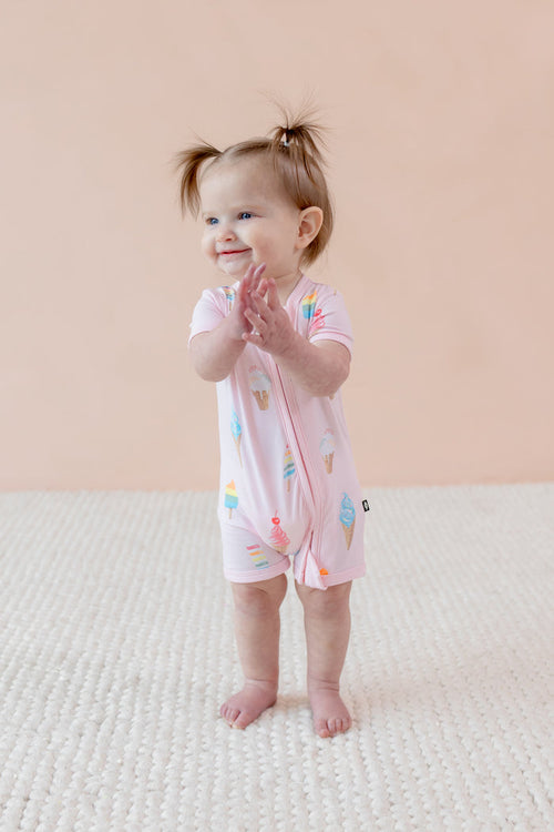Child wearing a Sakura Ice cream print Zippered shortall romper a beige background