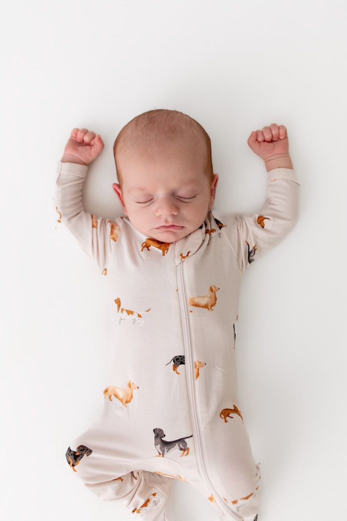 baby asleep wearing a dachshund printed zippered sleeper