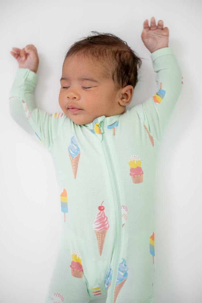 Baby wearing Zippered footie in Mint Ice cream print on a beige background