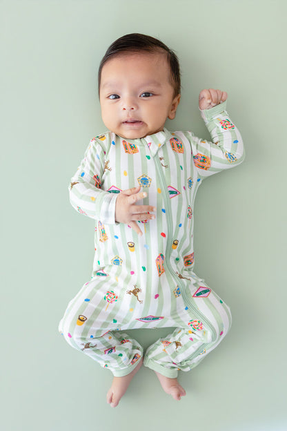 Baby wearing a green and white striped zippered romper with colorful Harry Potter patterns on a green background