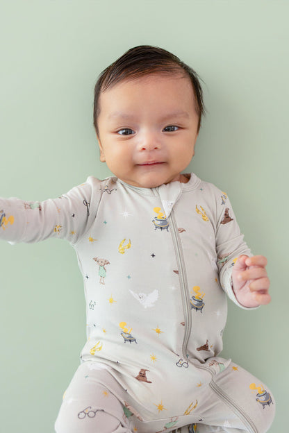 Baby wearing a Harry Potter patterned Zippered Romper on a green background
