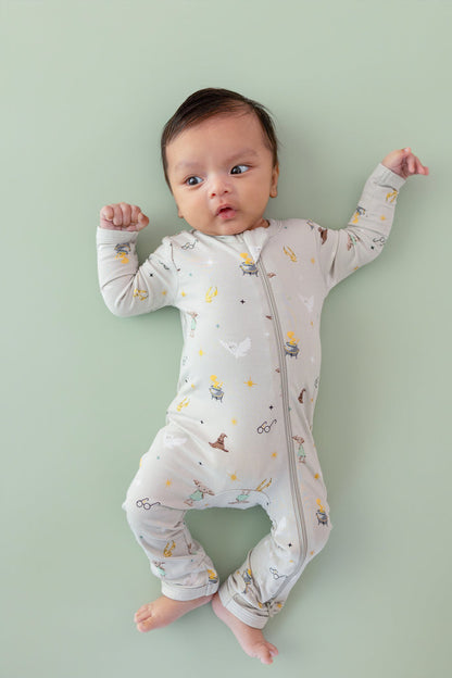 Baby wearing a Harry Potter patterned Zippered Romper on a green background